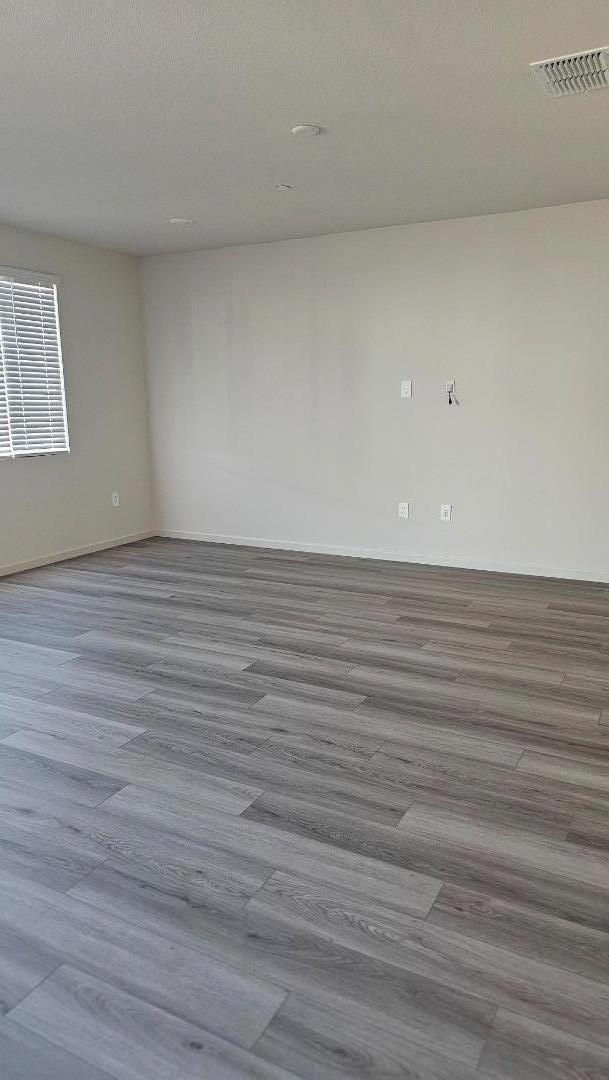 2865 Bering Street Manteca, CA 95337 - Photo 7 of 11 a view of an empty room with wooden floor and a window