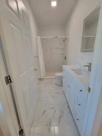 a bathroom with a sink a toilet and shower