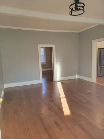 a view of empty room with wooden floor