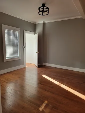 a view of a livingroom with wooden floor and window