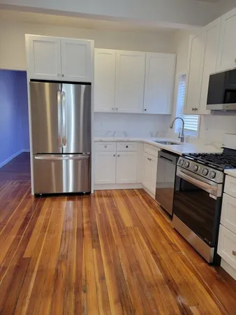 a kitchen with wooden floors and appliances