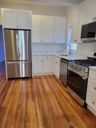 a kitchen with wooden floors and appliances