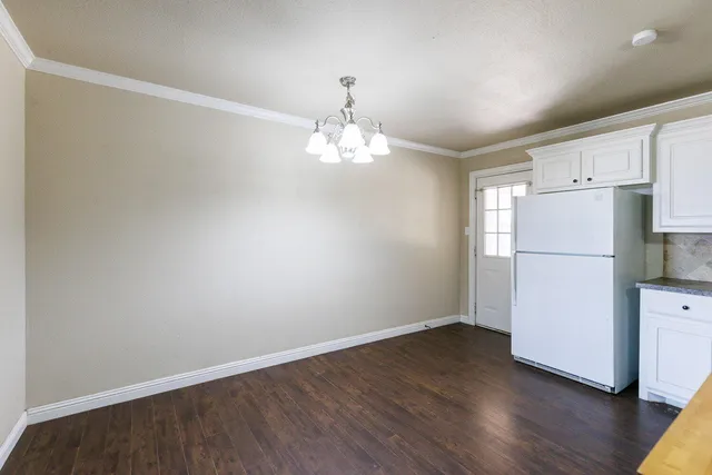 a view of a kitchen with wooden floor and a refrigerator