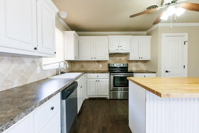 a kitchen with a sink stove top oven and cabinets