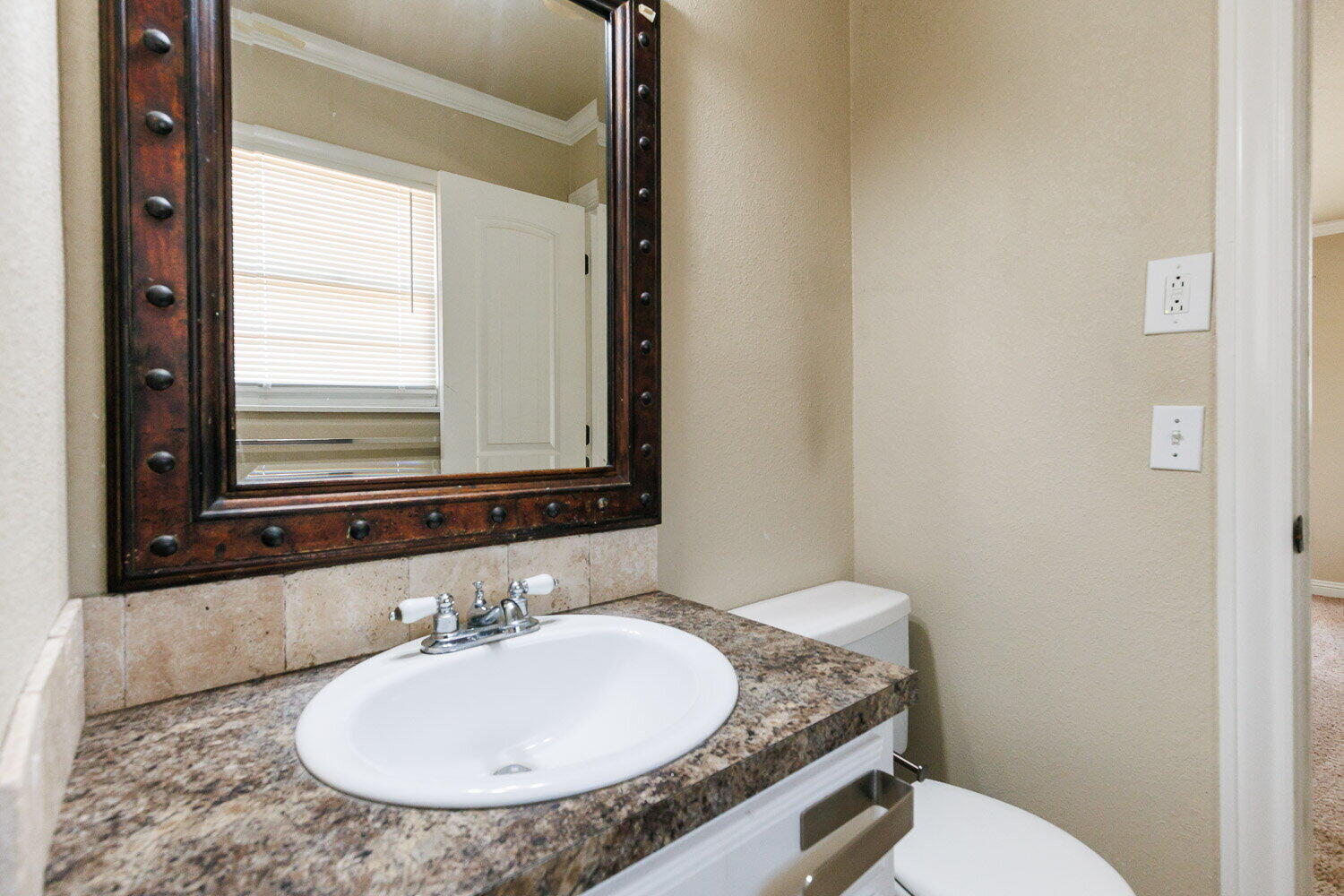 2505 52nd Street Lubbock, TX 79413 - Photo 25 of 37 a bathroom with a granite countertop sink and a mirror