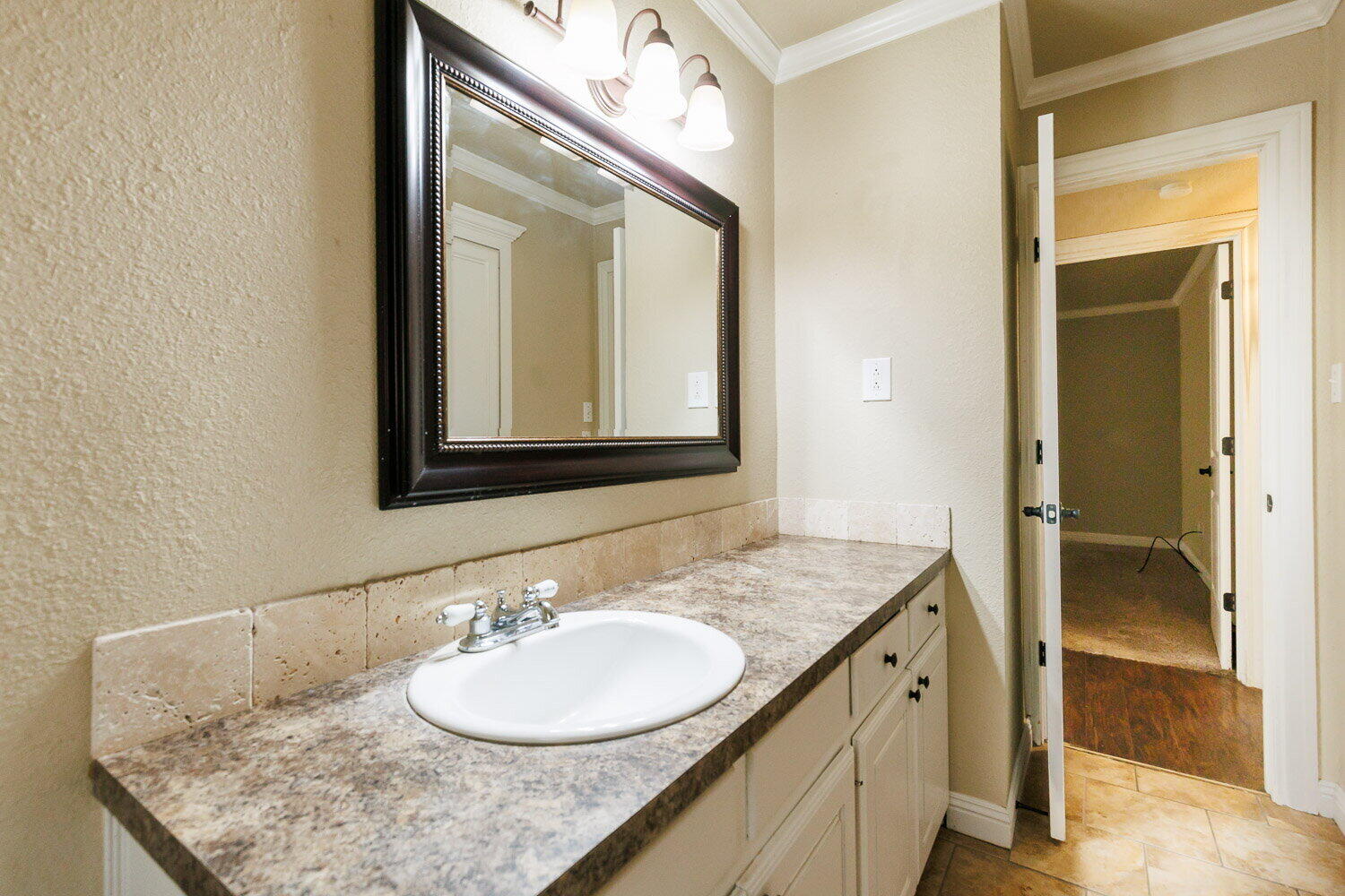2505 52nd Street Lubbock, TX 79413 - Photo 29 of 37 a bathroom with a granite countertop sink and a mirror