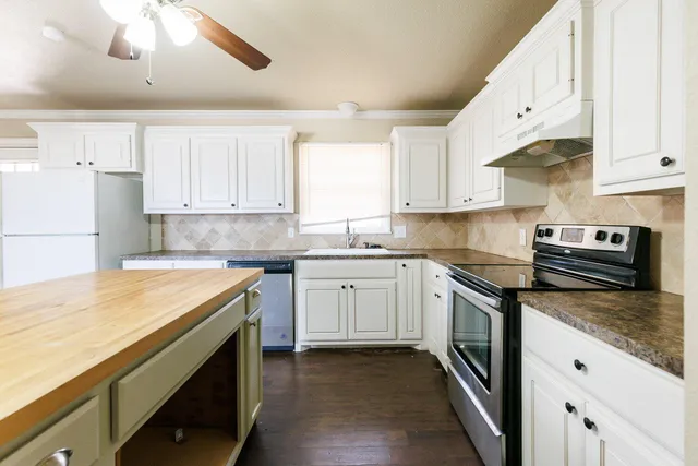 a kitchen with granite countertop white cabinets and white appliances