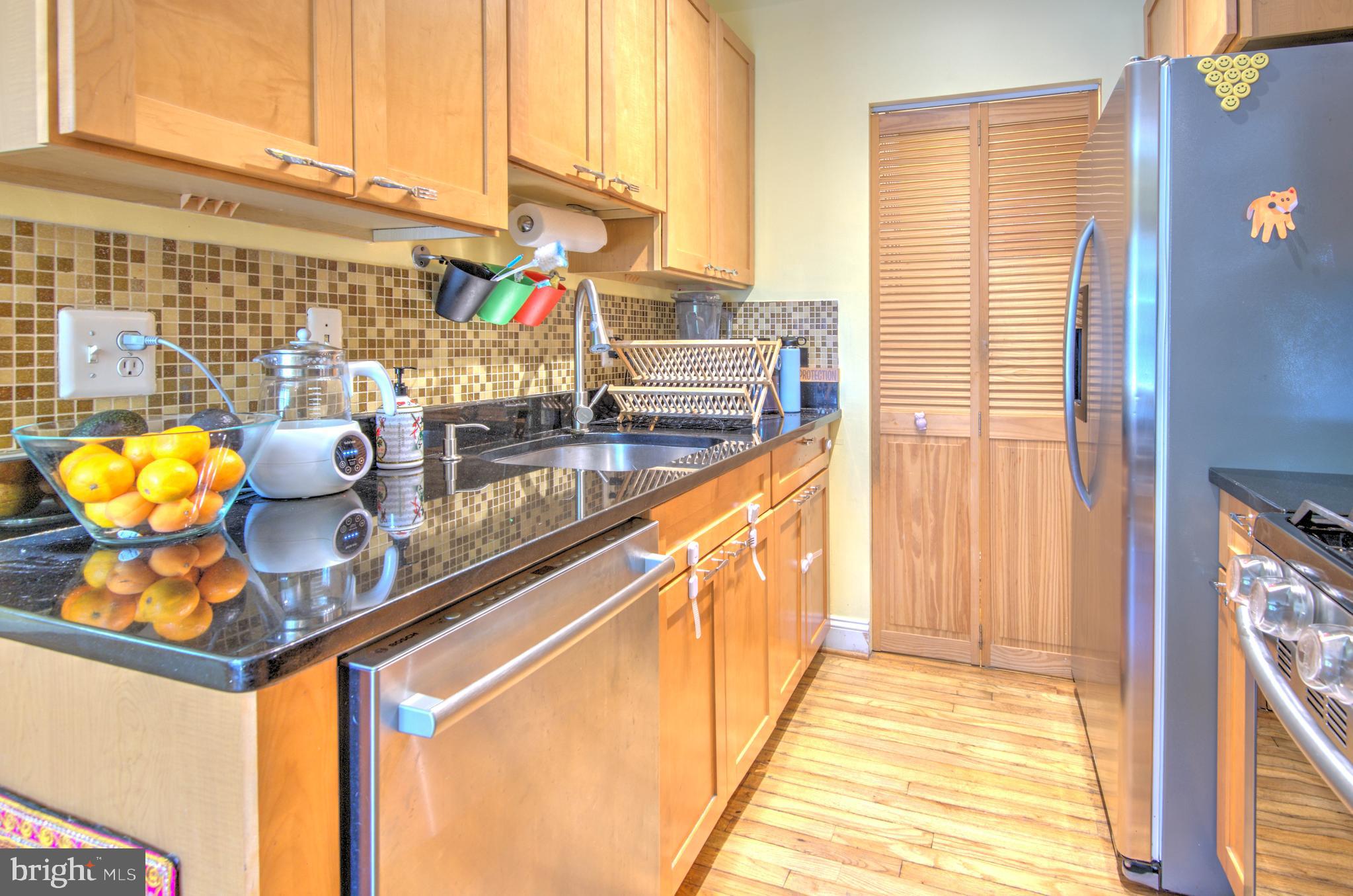 1302 Childress Street Northeast, Unit 4 Washington, DC 20002 - Photo 7 of 17 a kitchen with stainless steel appliances granite countertop a sink and a window
