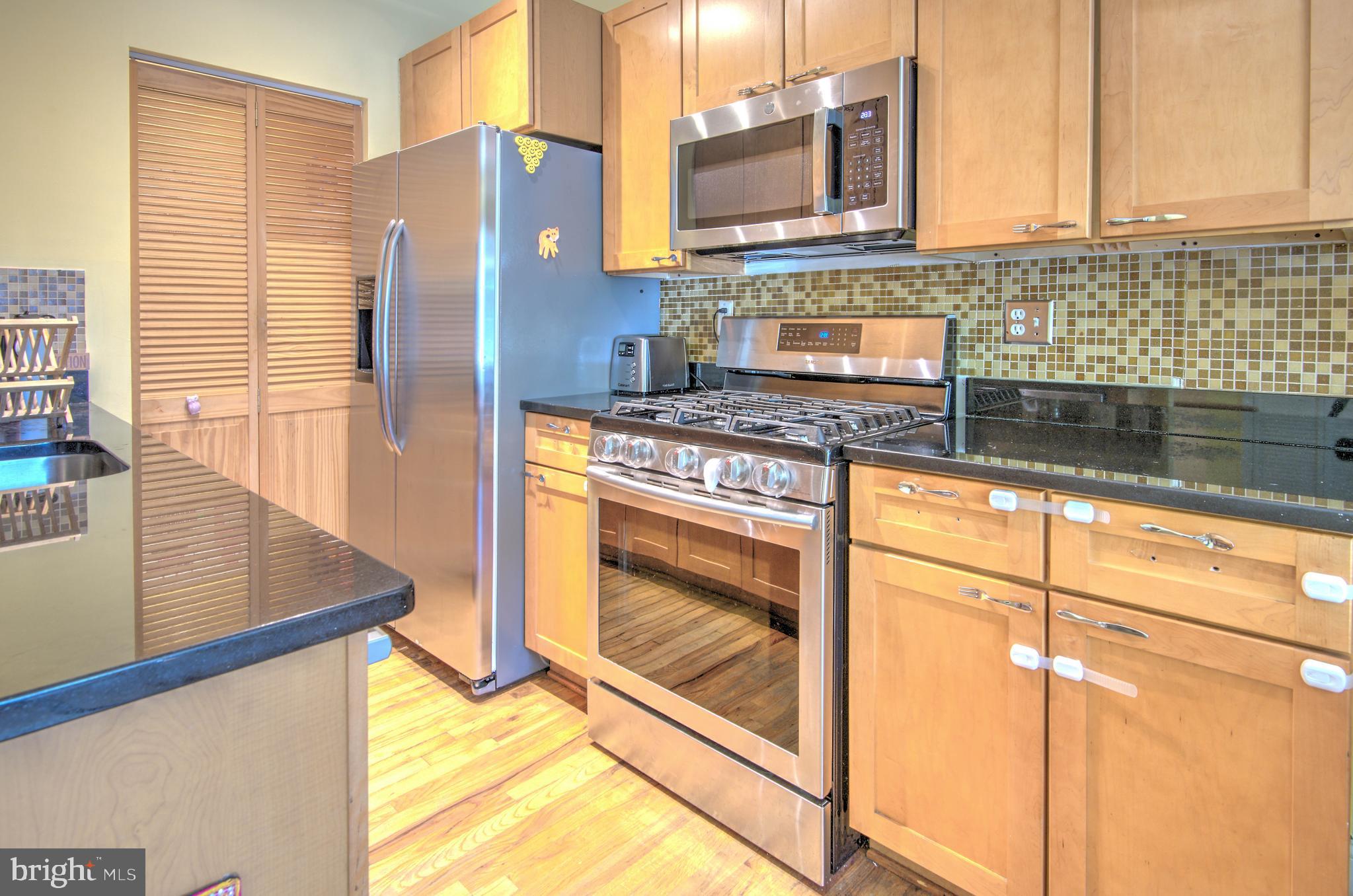 1302 Childress Street Northeast, Unit 4 Washington, DC 20002 - Photo 8 of 17 a kitchen with stainless steel appliances granite countertop a sink stove and refrigerator
