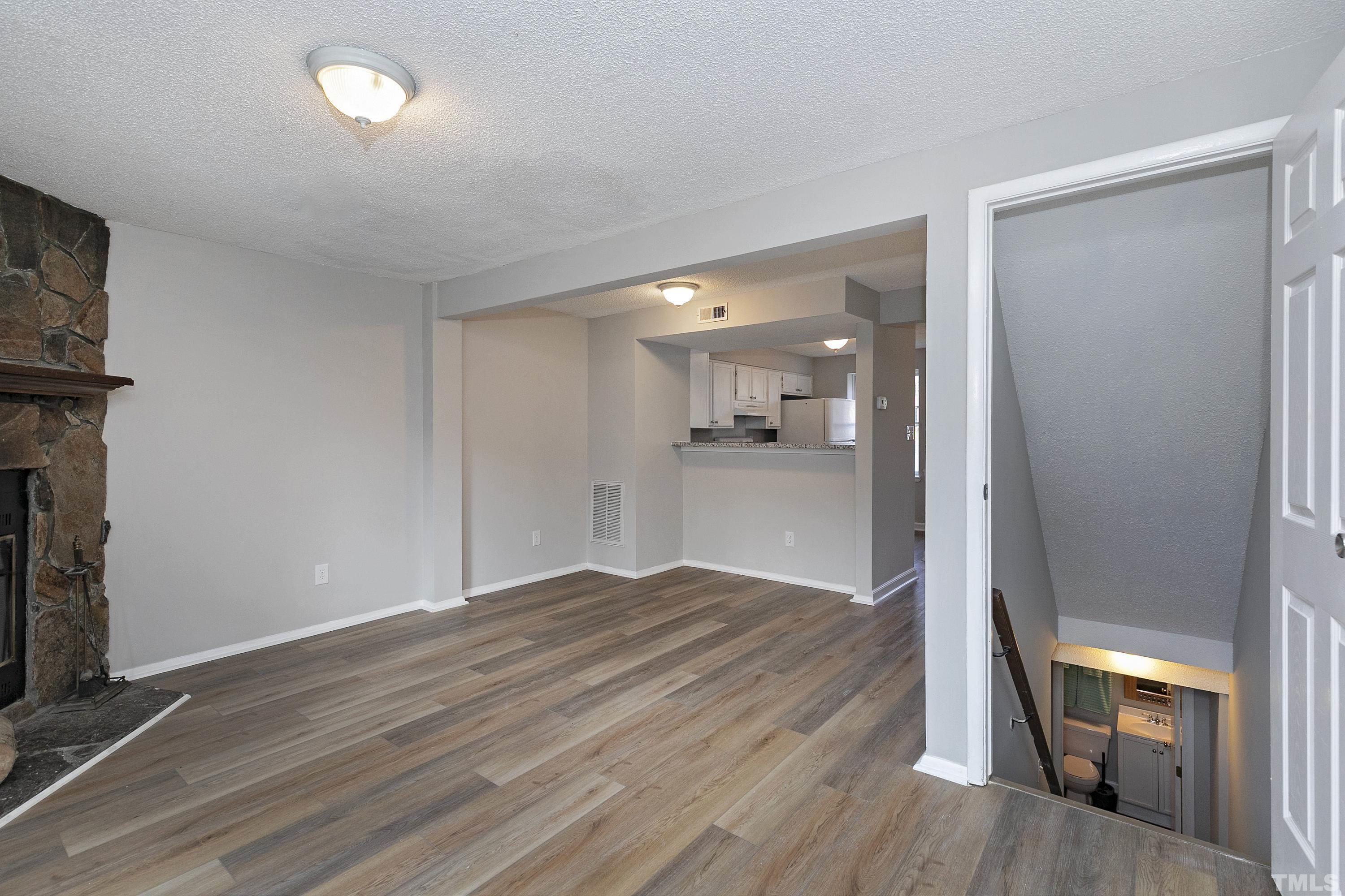 7735 Kelley Court Raleigh, NC 27615 - Photo 18 of 26 a view of a room with wooden floor and a kitchen