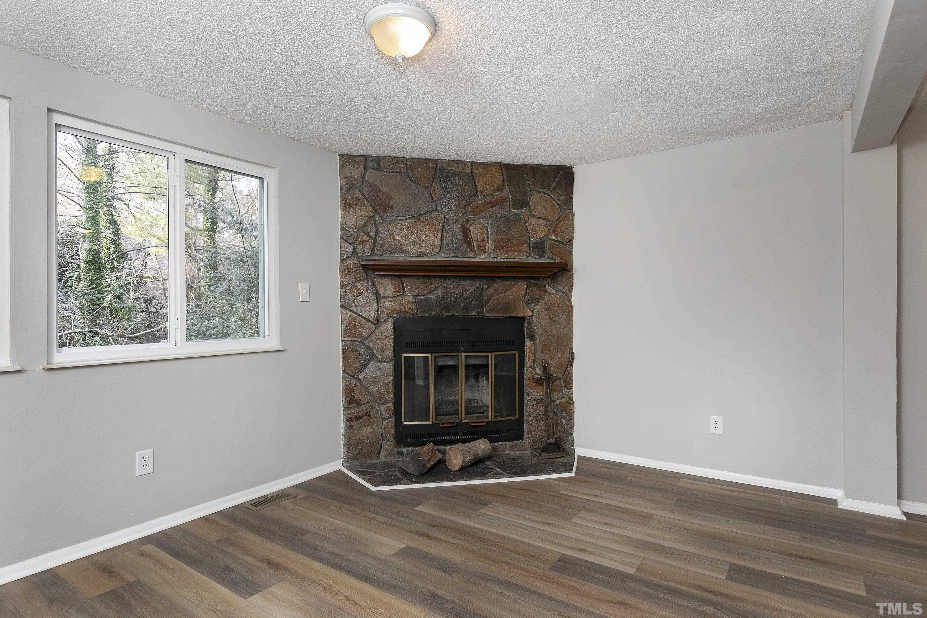 7735 Kelley Court Raleigh, NC 27615 - Photo 4 of 26 a view of an empty room with wooden floor and a window