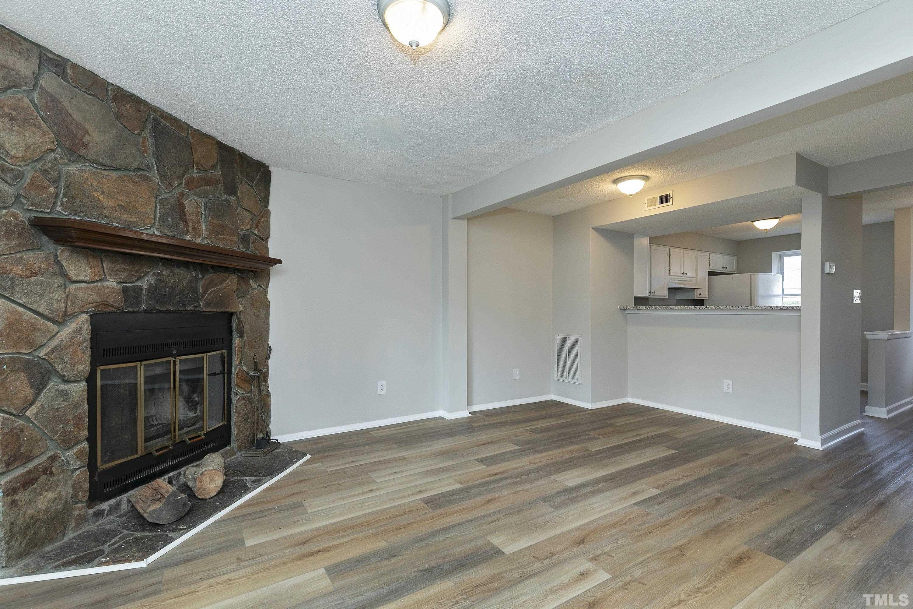 7735 Kelley Court Raleigh, NC 27615 - Photo 5 of 26 a view of empty room with wooden floor and fireplace