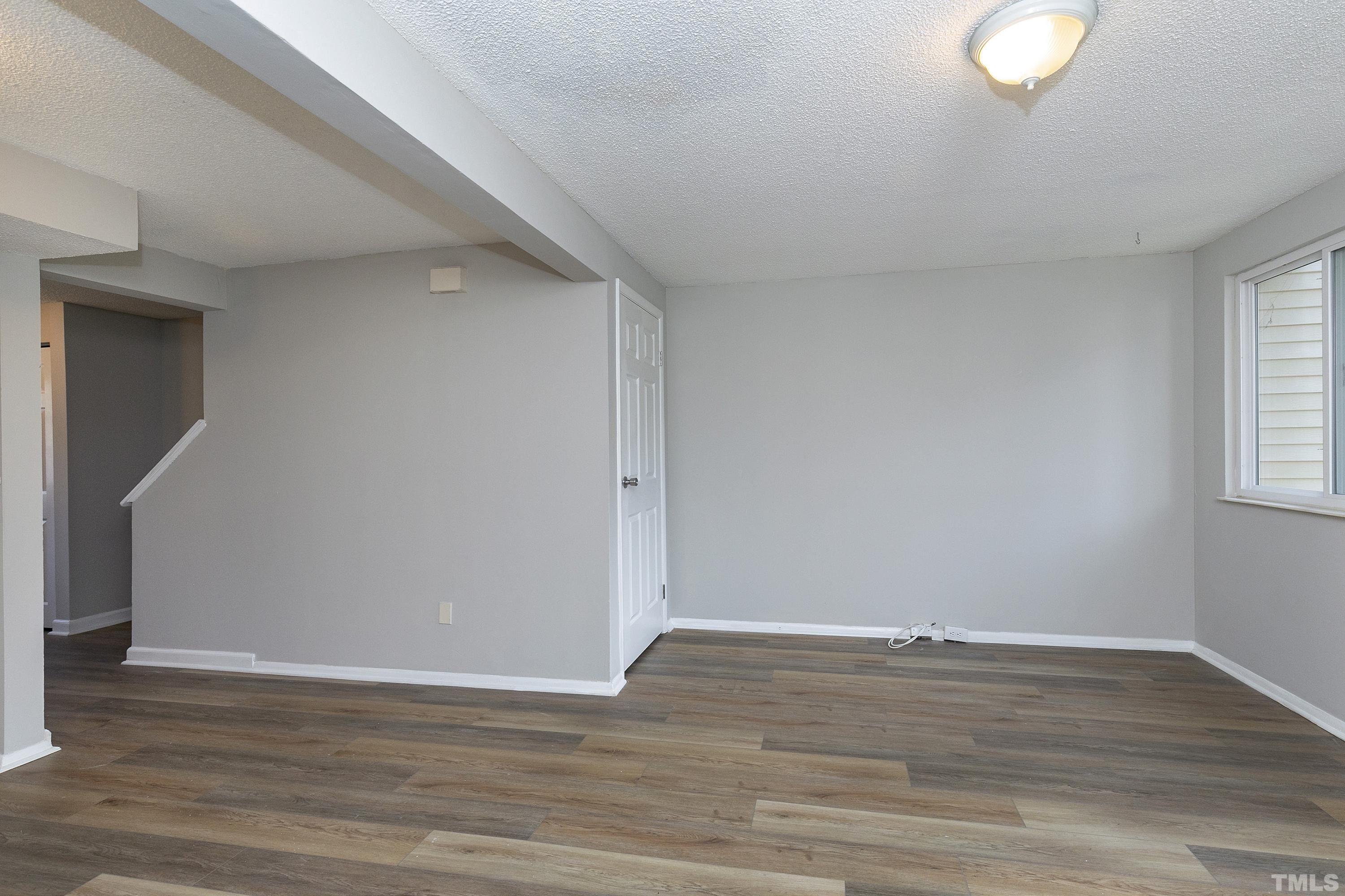 7735 Kelley Court Raleigh, NC 27615 - Photo 6 of 26 a view of an empty room with wooden floor and a window