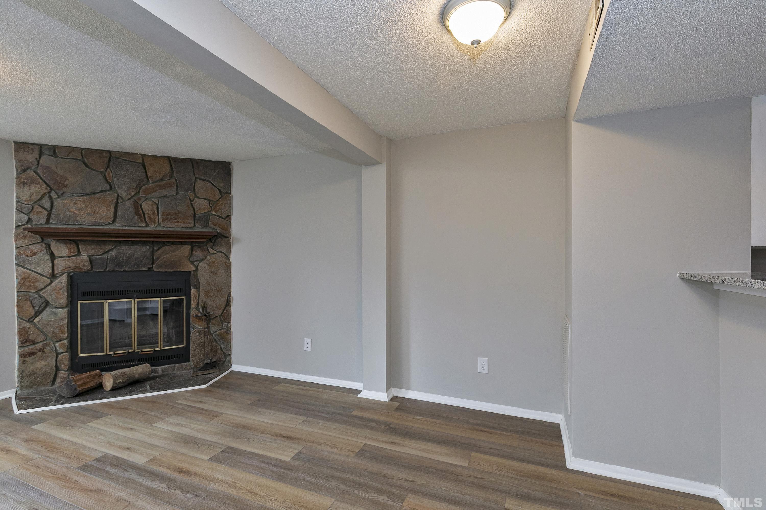 7735 Kelley Court Raleigh, NC 27615 - Photo 8 of 26 a view of a livingroom with wooden floor and a fireplace