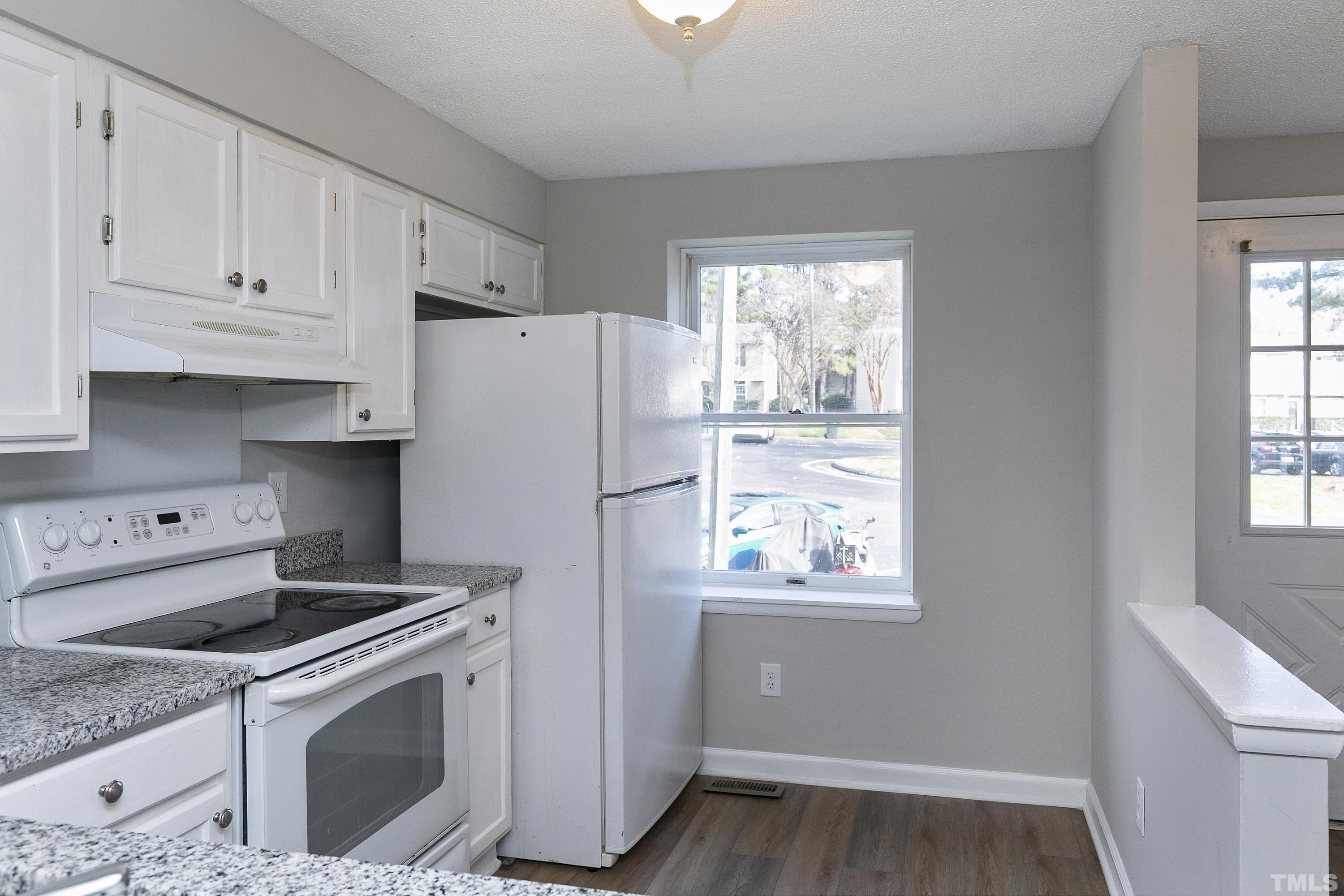 7735 Kelley Court Raleigh, NC 27615 - Photo 10 of 26 a kitchen with a stove a refrigerator and a window