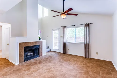 a view of an empty room with a fireplace and a window