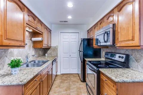 a kitchen with stainless steel appliances granite countertop a stove a sink and a microwave