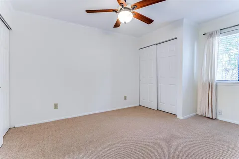 an empty room with closet and windows