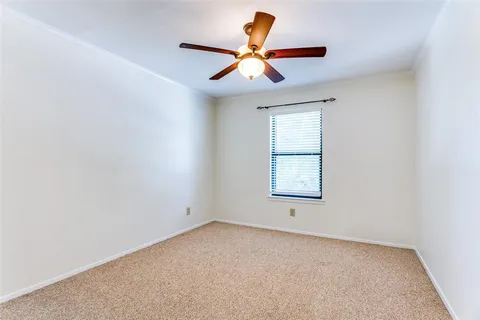 an empty room with a window and a ceiling fan