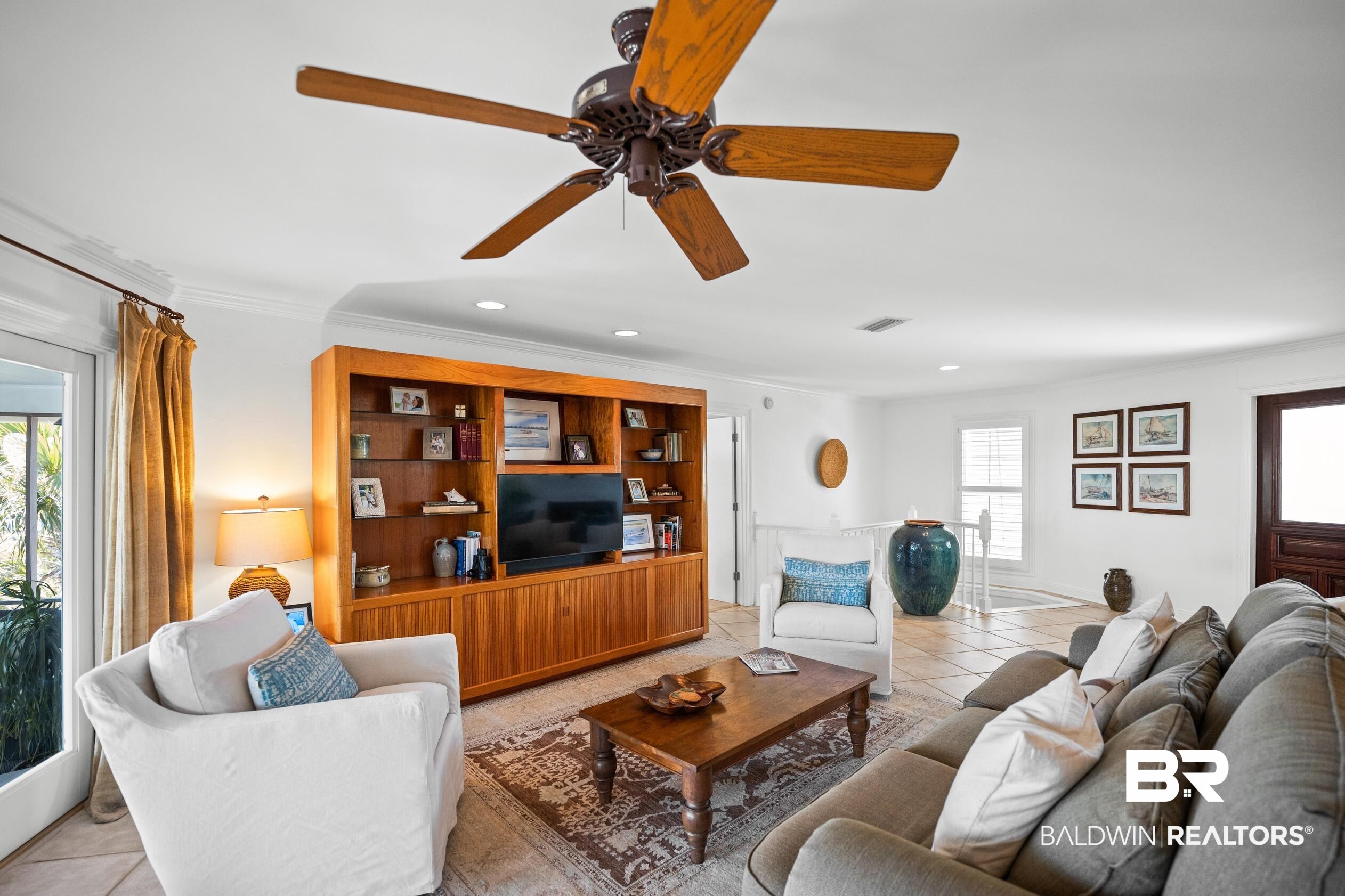31304 River Road Orange Beach, AL 36561 - Photo 18 of 78 Living area featuring crown molding, light tile patterned flooring, a ceiling fan, and visible vents