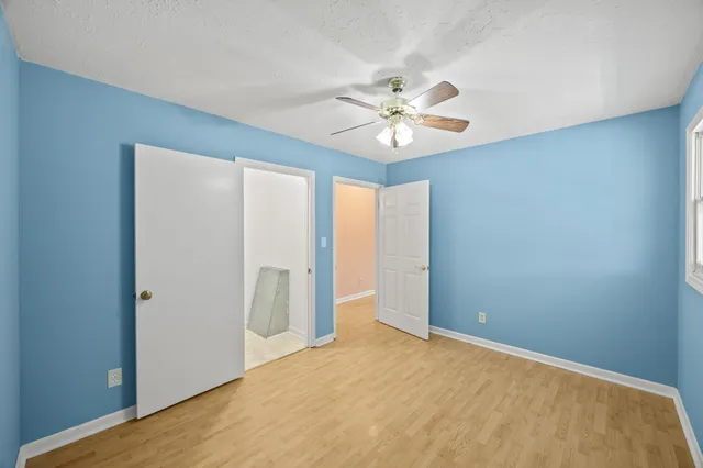 an empty room with chandelier fan