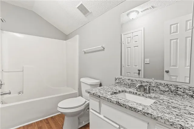 a bathroom with a sink toilet vanity and shower