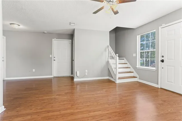 an empty room with wooden floor and windows