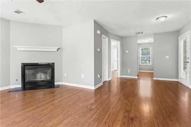 a view of an empty room with a fireplace and a window