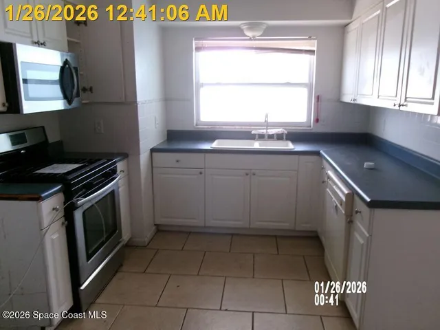a kitchen with a stove window and cabinets