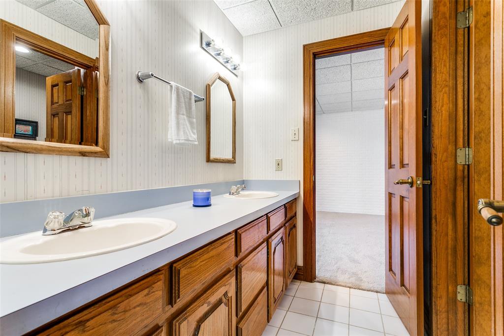 1557 Latigo Hills Road Bartonville, TX 75022 - Photo 30 of 40 Full bath featuring wallpapered walls, double vanity, light colored carpet, light tile patterned floors, and a drop ceiling