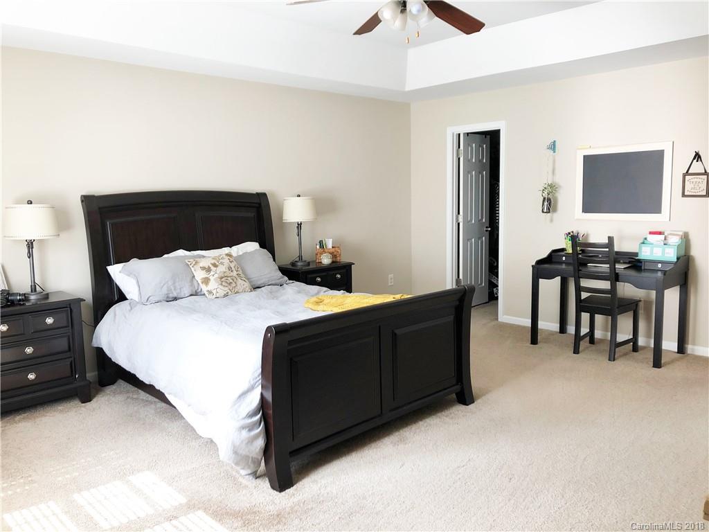 777 Jones Branch Road Fort Mill, SC 29715 - Photo 15 of 27 a bedroom with a bed and a chandelier