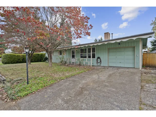 a view of a house with backyard and trees