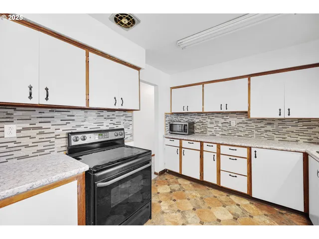 a kitchen with granite countertop a stove sink and cabinets