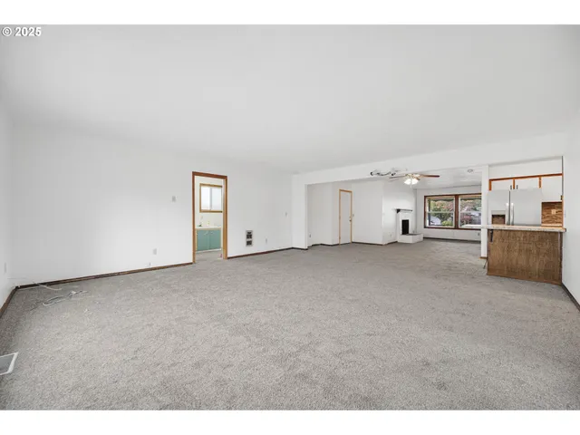 a view of an empty room with a kitchen