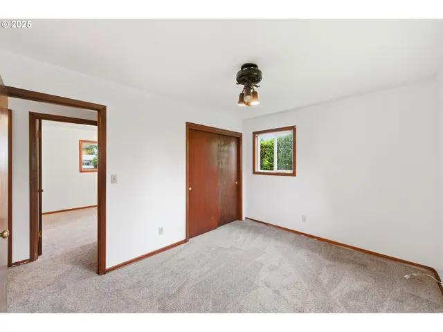 a view of a room with a ceiling fan and window