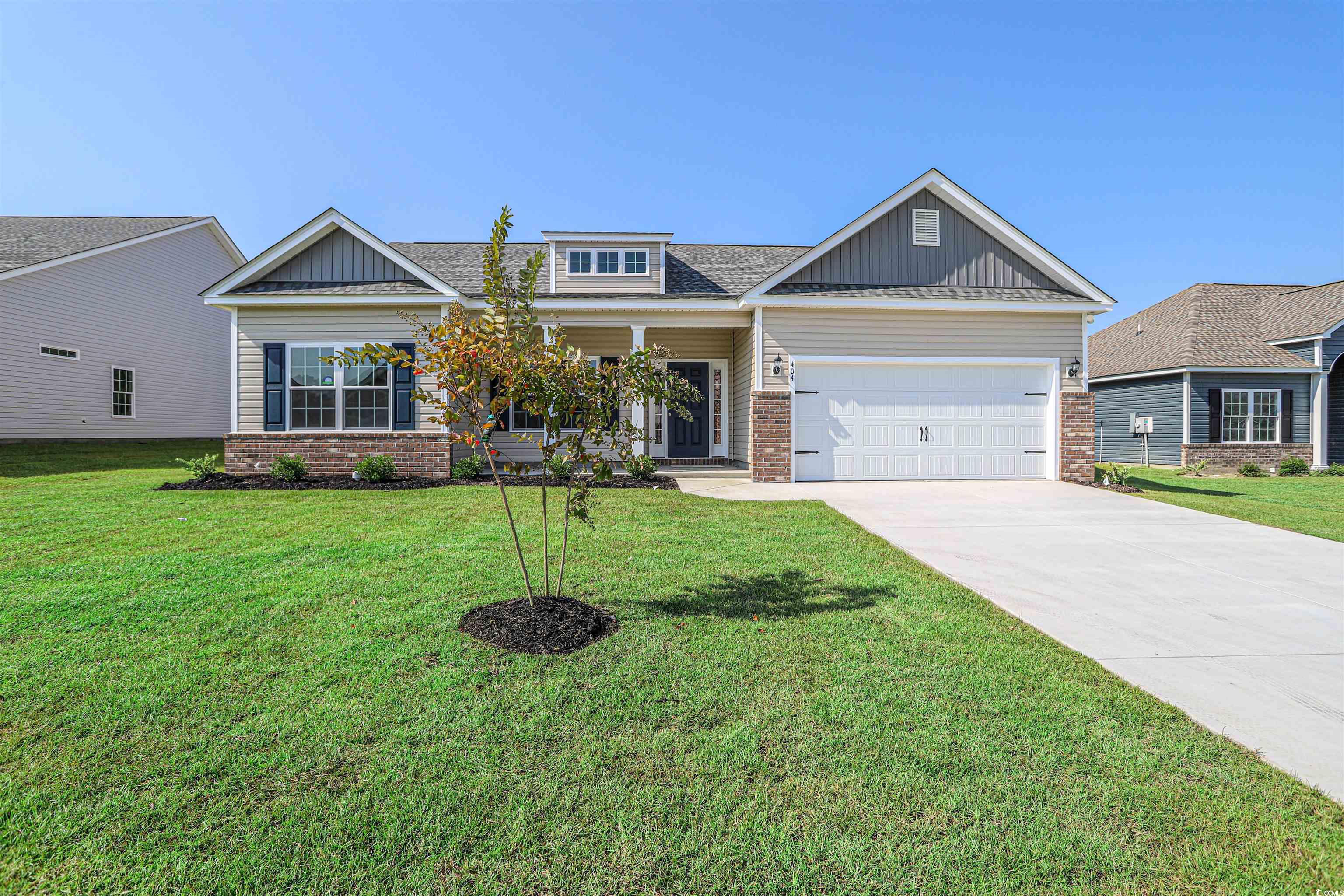 Craftsman inspired home featuring covered porch, driveway, a front lawn, brick siding, and an attached garage