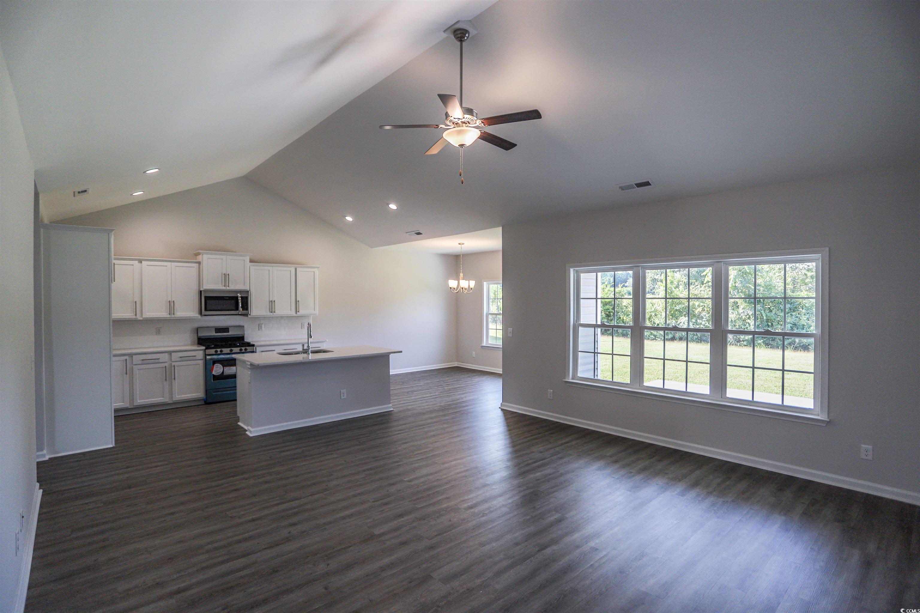611 Bay Street Aynor, SC 29544 - Photo 11 of 12 Kitchen with white cabinets, open floor plan, dark wood finished floors, an island with sink, and stainless steel appliances