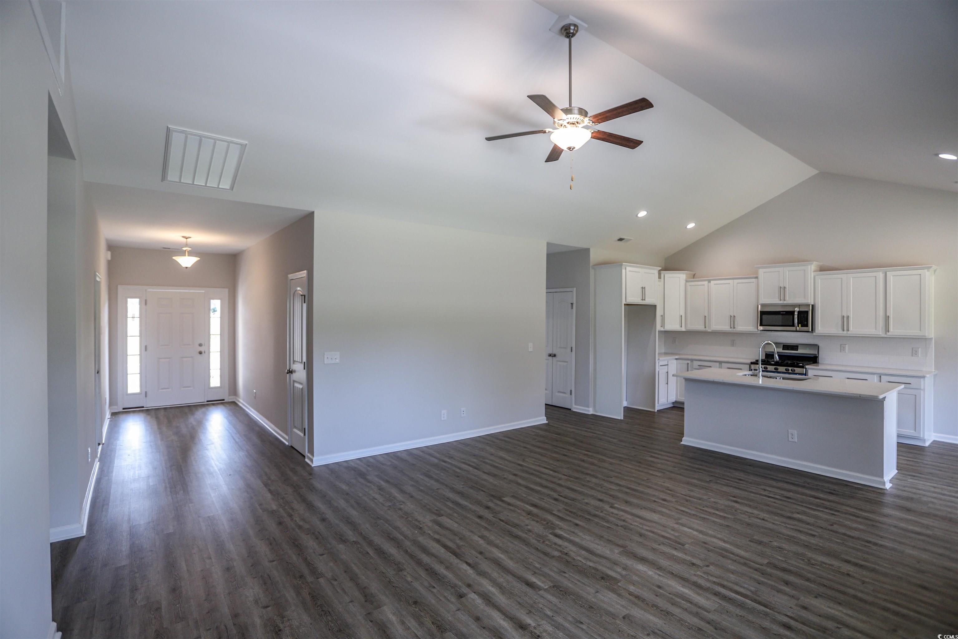 611 Bay Street Aynor, SC 29544 - Photo 12 of 12 Kitchen featuring white cabinetry, dark wood-style flooring, open floor plan, a ceiling fan, and high vaulted ceiling