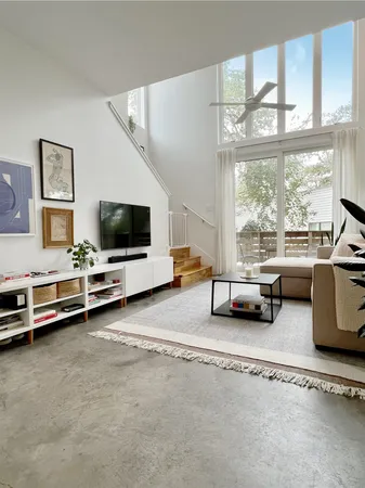 a view of a livingroom with furniture and a large window