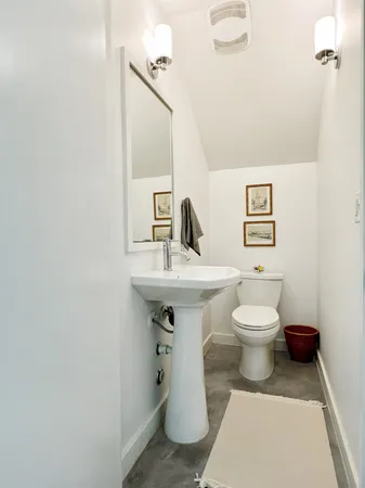 a bathroom with a toilet sink and mirror