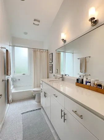 a spacious bathroom with a double vanity sink a mirror a bathtub and shower
