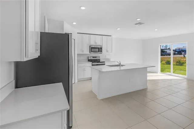 a kitchen with stainless steel appliances a refrigerator sink and microwave
