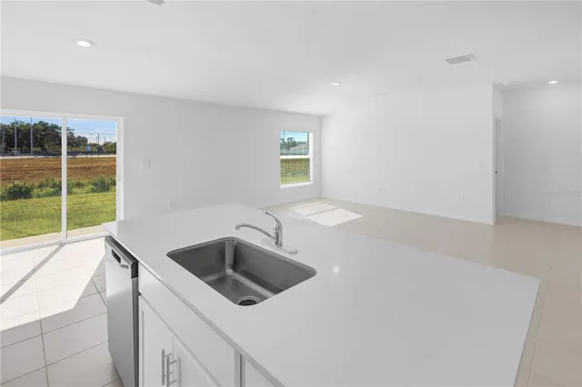 a view of kitchen with stainless steel appliances granite countertop a stove a sink and a refrigerator