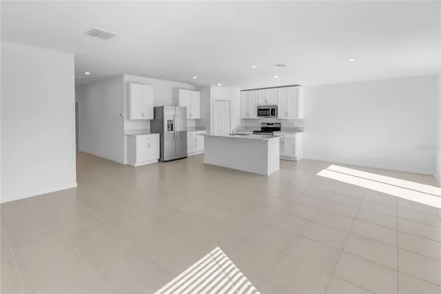 a view of kitchen with stainless steel appliances cabinets and window