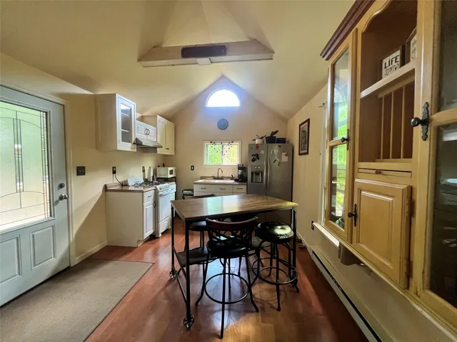 a kitchen with a table chairs refrigerator and cabinets