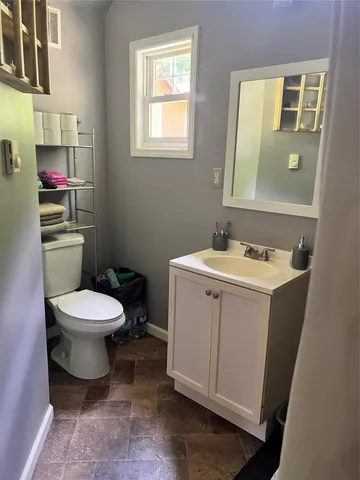 a bathroom with a toilet sink and mirror