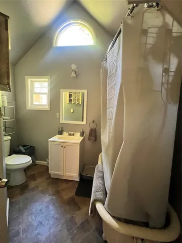 a bathroom with a sink and mirror with toilet