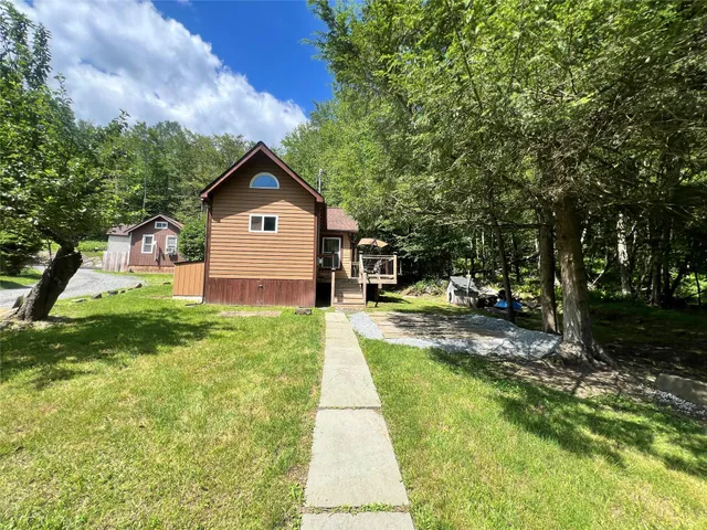 a front view of a house with a yard and trees
