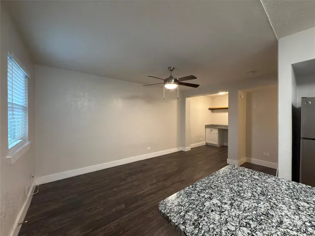 a view of a livingroom with wooden floor and a ceiling fan