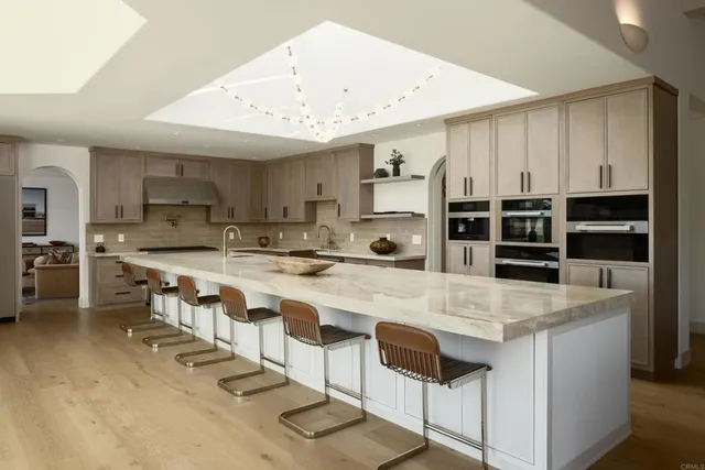 a large kitchen with kitchen island a sink a stove and a refrigerator